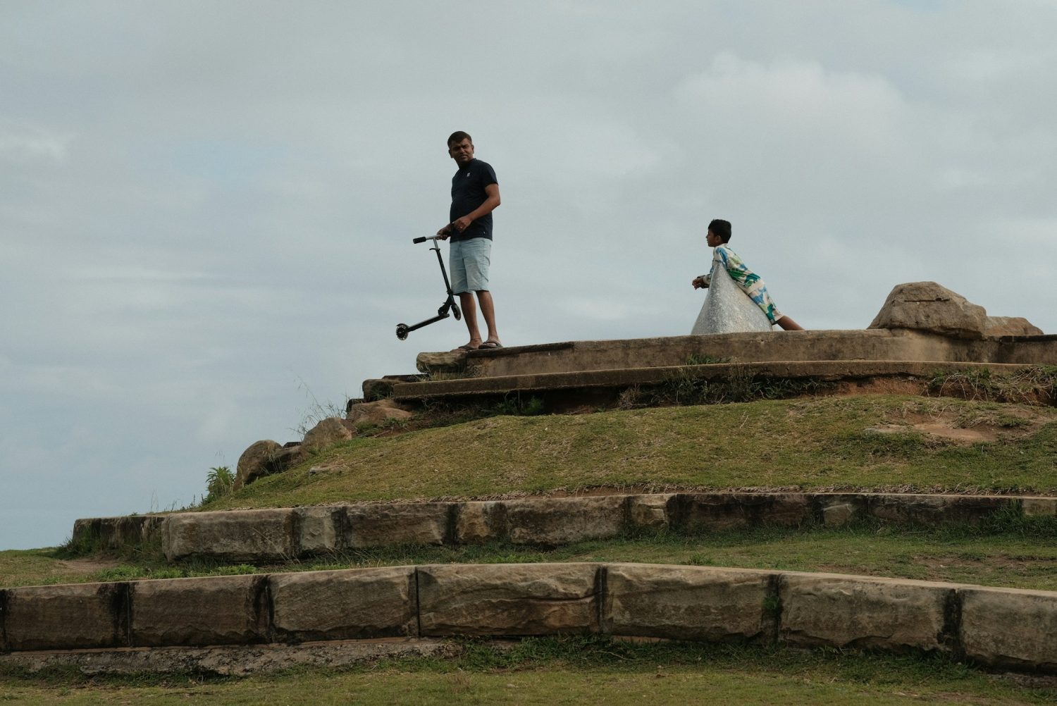 A couple of people standing on top of a hill